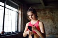 Young female boxer preparing for boxing fight. Athletic woman wearing strap on wrist before boxing practice in gym Royalty Free Stock Photo