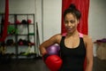 Young female boxer, sporty girl, athlete woman, sports woman, wearing red boxing gloves, looks at camera posing against sports Royalty Free Stock Photo