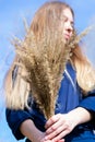 Young female with bunch of dried grass in hands. Long haired woman