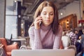 Woman works remotely online from cafe while quarantine coronavirus is in effect. Concept of checking mail, blogger, freelancer