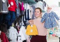 Female buyer choosing clothes for infant