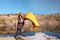 Young female camper with sleeping bag in wilderness Royalty Free Stock Photo