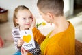 Young female cancer patient thanking her adorable young daughter for homemade I LOVE MOM greeting card. Happy Mother`s Day .