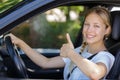 young female car driver making thumbs up gesture Royalty Free Stock Photo