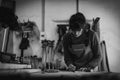 A young female carpenter working as wood designer in a small carpentry workshop. Young business woman handcrafting a piece of