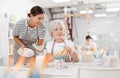 Young female ceramicist teaching elderly woman to paint ceramics in pottery studio Royalty Free Stock Photo