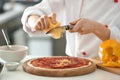 Young female chef cooking tasty pizza in kitchen, closeup Royalty Free Stock Photo