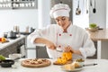 Young female chef cooking tasty pizza in kitchen Royalty Free Stock Photo