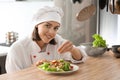 Young female chef preparing tasty salad in kitchen Royalty Free Stock Photo
