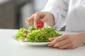 Young female chef preparing tasty salad in kitchen, closeup Royalty Free Stock Photo