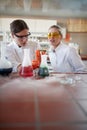 Young female chemistry students in the university laboratory doing an experiment with chemicals. Science, chemistry, lab, people