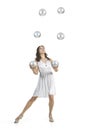 A young female circus performer, juggles silver balls. Royalty Free Stock Photo