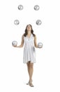 A young female circus performer, juggles silver balls. Royalty Free Stock Photo