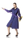 Young female cleaner has fun with broom as if she is a rock musician. Royalty Free Stock Photo