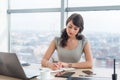 Young female clerk sitting at modern office making notes in her notepad. Employee working on the work table with