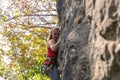 Young female climber is scaling a rocky cliff her grip secure as she reaches for the next handhold Royalty Free Stock Photo