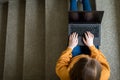 Young female college student sitting on stairs at school, writing essay on her laptop. Education concept. Royalty Free Stock Photo