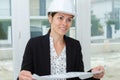 Young female construction specialist reviewing blueprints at construction site Royalty Free Stock Photo
