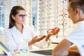 Young female consulting teenager in optical store