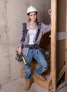 Young female contractor with carpenter equipment