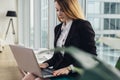 Young female copywriter writing an advertising text typing on laptop keyboard sitting in office