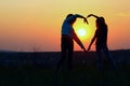 Young Female Couple Making Heart Shape With Hands At Sunset. Abstract Love Background. People, Love, Friendship Background.