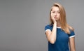 Young female covers face hand, feels fatigue. Weariness and people. Studio shot, gray background. Copy space