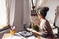 Young female creative pretty african american artist paints picture with oil paints in art studio Royalty Free Stock Photo