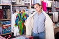 Young female customer examining new bathrobe Royalty Free Stock Photo