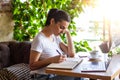 Young female with cute smile sitting with portable net-book in modern coffee shop interior during recreation time, charming happy Royalty Free Stock Photo