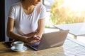 Young female with cute smile sitting with portable net-book in modern coffee shop interior during recreation time, charming happy Royalty Free Stock Photo