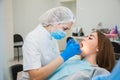 Young female dentist curing patient`s teeth filling cavity