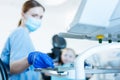 Young female dentist taking dental probe from tray