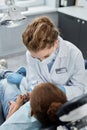 Young female dentist working with child at dental checkup in clinic Royalty Free Stock Photo