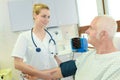 Young female doctor checking blood pressure senior male patient Royalty Free Stock Photo