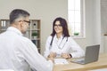 Young female doctor consulting mature male patient in medical clinic Royalty Free Stock Photo