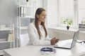 Young female doctor consulting patient online, using laptop computer at her office. GP making video call to sick client Royalty Free Stock Photo