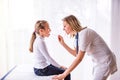 Young female doctor examining a small girl in her office. Royalty Free Stock Photo