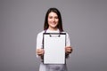 Young female doctor holding empty folder with files of desease illness. Specialist point by pen blank clipboard. Woman in medical