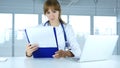 Young Female Doctor Holding Medical Reports, Talking with Patient Royalty Free Stock Photo