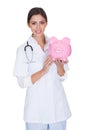 Young Female Doctor Holding Piggy Bank Royalty Free Stock Photo