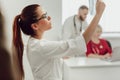 Young female doctor in hospital looking at x-ray. The other two doctors communicate in the background Royalty Free Stock Photo