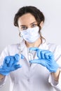 Young female doctor in medical mask holding syringe, medical injection in hand with glove Royalty Free Stock Photo