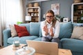 Young female doctor medical worker working from home sitting on sofa having video call with nervous sick patient listening and