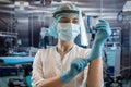 Young female doctor or nurse assistant surgeon putting on gloves standing in operation room Royalty Free Stock Photo