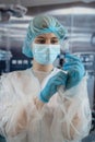 Young female doctor or nurse assistant surgeon putting on gloves standing in operation room Royalty Free Stock Photo