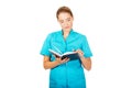 Young female doctor or nurse holding black notes Royalty Free Stock Photo