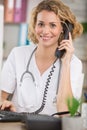 Young female doctor and practitioner working at reception desk Royalty Free Stock Photo