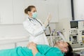 Young female doctor preparing syringe for male patient