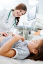 Chatty female doctor pressing her fingers against stomach of a little girl Royalty Free Stock Photo
